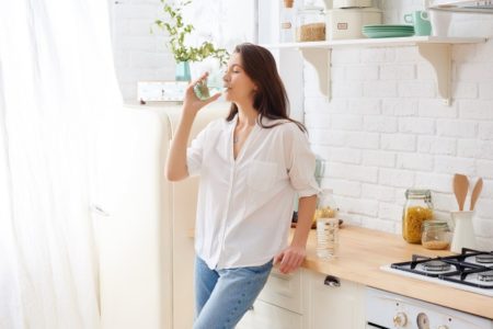 ウォーターサーバーからお水を飲む女性の画像