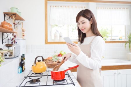 キッチンでお味噌汁を作る女性の画像